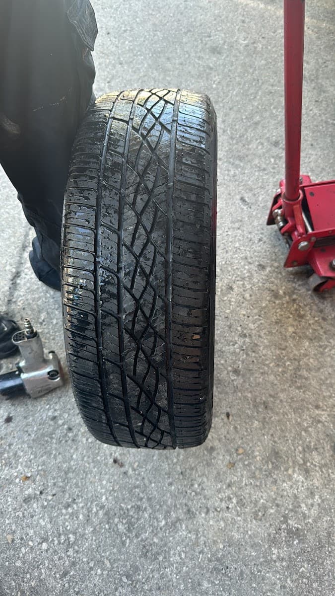 Technician holding up a tire for inspection at George's Tires